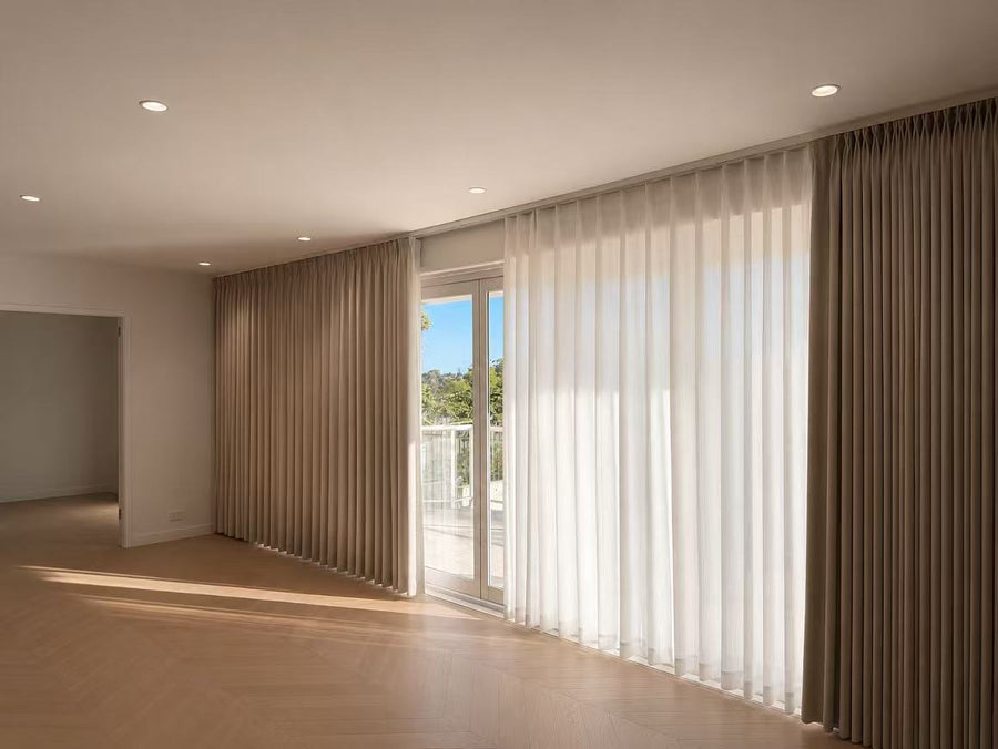 Wall-to-wall taupe blockout curtains layered with white sheers along balcony doors